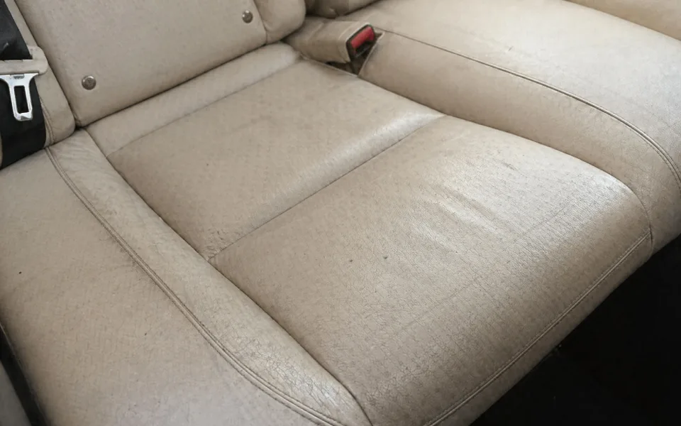 Asiento de cuero beige con grietas de suciedad y aspecto desgastado por falta de hidratación